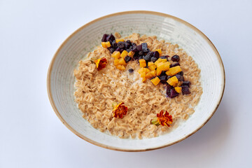 Delicious Oatmeal Bowl Topped with Dried Fruits and Flowers for a Nutritious Breakfast Experience