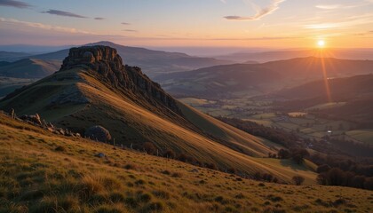 Obraz premium Panoramic view of a vibrant sunrise over the rugged mountain landscape, with soft clouds highlighting the scenic nature