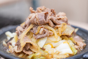 A traditional Asian clay pot rice dish is served piping hot, nestled in a rustic earthenware pot. Steam rises from the sizzling surface, revealing layers of tender sliced meat, crisp bean sprouts