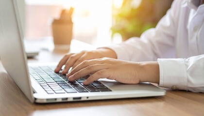 Close-up shot of a person typing on a laptop