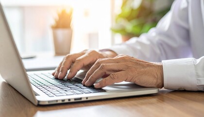 Person typing on a laptop, close-up of hands working on keyboard. The person is deeply focused on the task at hand