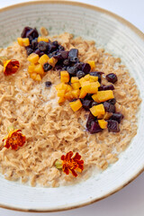 Deliciously Prepared Oatmeal Bowl Topped with Fresh Fruits and Edible Flowers for a Nutritious Start to Your Day