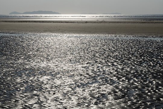 view of the shiny beach with sunlight reflections