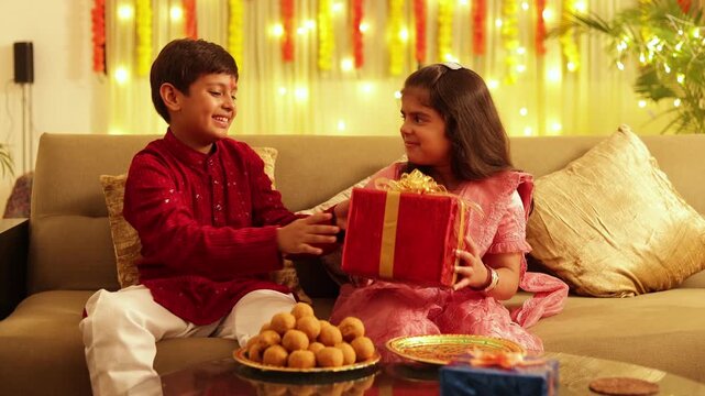 Happy Indian brother and sister celebrating Raksha Bandhan at home, exchanging gift and sharing family moment.  festival celebrating the bond of siblings, love, affection, childhood, celebration