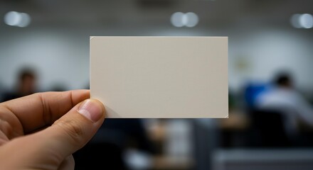 Hand Holding Blank White Business Card in Office Setting