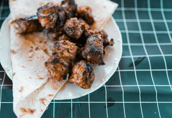 Tasty barbeque meat cooked on an open fire.