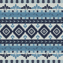 Seamless indigo ikat patterns in ethnic tribal style, featuring geometric diamond shapes and woven texture in blue tones.