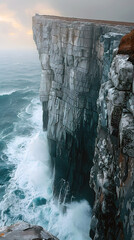 dramatic ocean waves crashing against high cliff with powerful spray and textured rocky coastline under moody lighting
