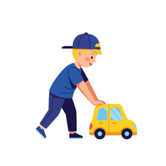 A cute little boy wearing a blue baseball cap pushes a small yellow toy car across the floor.