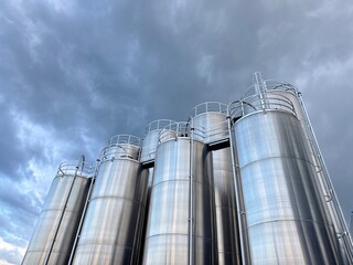 Row of tall silo tanks are lined up in a row