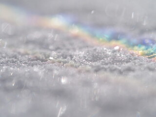 Snow covered ground with a rainbow in the sky