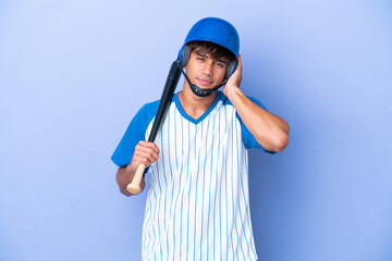 Baseball caucasian man player with helmet and bat isolated on blue background frustrated and covering ears