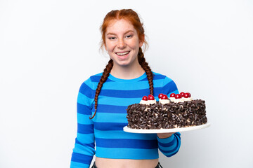 Young reddish woman holding birthday cake isolated on white background with surprise facial...