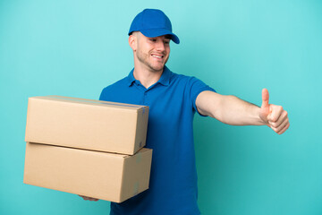 Delivery caucasian man isolated on blue background giving a thumbs up gesture