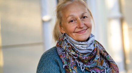Portrait of an old smiley beautiful lady in a cozy warm sweater.