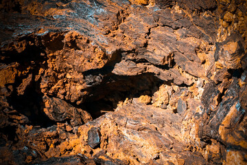 Lava formations, stones, black basalt in the rocks closeup on a volcano terrain.