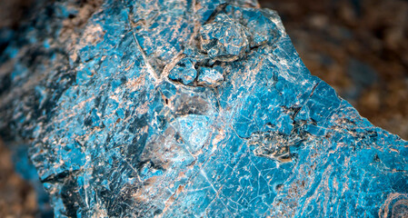A blue natural stone with lots of details closeup, a piece of volcanic origin stone.