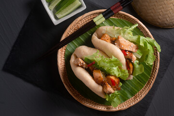 Food concept Homemade organic chicken Bao Buns or Gua Bao in bamboo stream tray on black background with copy space