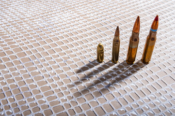 A bullet with a gold tip is sitting on a white background. The bullet is shiny and has a pointed tip