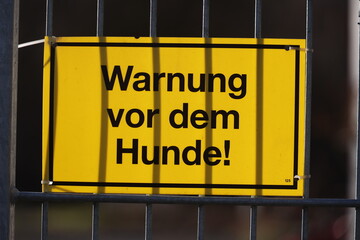 A warning sign is hanging on a fence