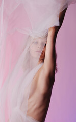 Sexy nude woman posing on rose background in studio
