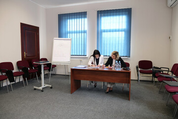 Two business women work in the office to solve problems and sign agreements.