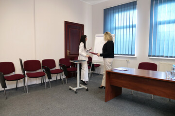 Two business women work in the office to solve problems and sign agreements.