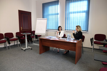Two business women work in the office to solve problems and sign agreements.