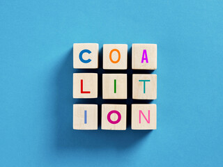 Coalition concept shown by wooden cubes over blue background