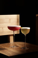 Two elegant cocktails on a wooden chair in soft light