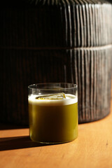 Green Cocktail with Orange Peel Garnish