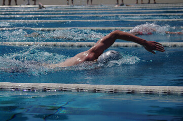 Man is swimming in a pool with his arms outstretched
