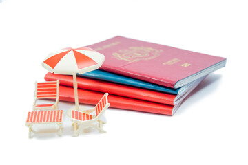 Miniature chairs and umbrella with passport for travelling concept.