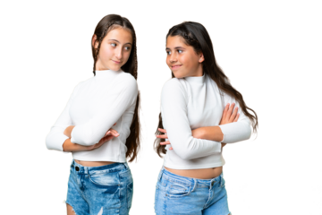 Friends girls holding gift and a birthday cake over isolated chroma key background looking over the shoulder with a smile