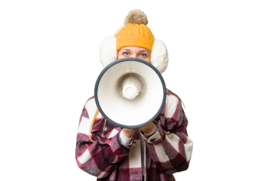 Young pretty blonde woman wearing winter muffs over isolated chroma key background shouting through a megaphone