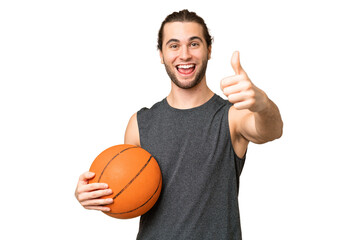 Young basketball player man over isolated background with thumbs up because something good has...