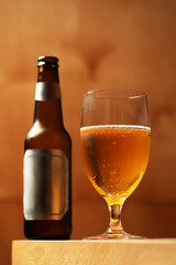 Glass of Light Beer with Bottle on Wood Background