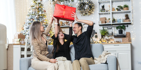 parents and Little girl with Christmas gifts near a Christmas tree at home