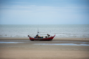 Fototapeta premium View landscape seascape and clouds sky wave in sea ocean and thai fisher people stop wooden fishing boat or wood fishery ship wait catch fish and marine life on Phetburi Beach in Phetchaburi, Thailand