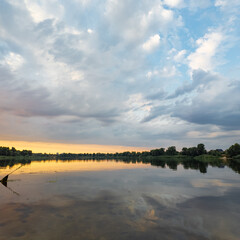 Obraz premium very beautiful sunset with water. summer evening landscape with reflection of clouds in water. setting sun on horizon. summer landscape with lake. reflection of trees in water. sunrise on river
