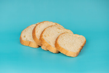 Neatly sliced white bread loaf arranged on a vivid blue background, showcasing soft texture and golden crust.