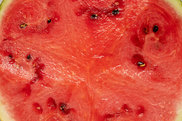 Juicy watermelon pulp with seeds close-up in a cut, texture of fresh watermelon, macro photography, ripe fruit, dessert