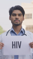Vertical Photo of Indian Doctor Holding HIV Poster