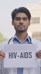 Vertical Photo of Indian Doctor Holding HIV-AIDS Poster