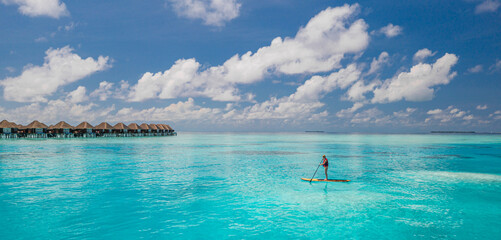 Stunning aerial view Maldives water villas tropical island turquoise lagoon bay carefree woman sup board adventure outdoor activity turquoise sea sunny sky summer luxury vacation ocean wallpaper