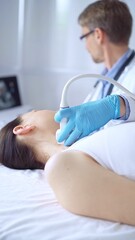 Fototapeta premium Doctor man wearing blue protective gloves is using ultrasound equipment on the neck of a patient woman, lying for examination. Medicine concept