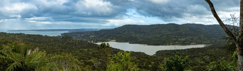 A panoramic view of the lush, green landscape of New Zealand, featuring Lower Ninotupu Reservoir. The photo captures the natural beauty and serene atmosphere of the country.