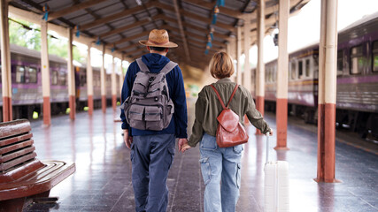 Asian older couple traveling train station journey vacation exploration retirement adventure togetherness freedom lifestyle