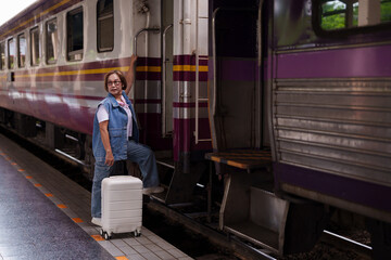 older asian woman traveling train station boarding luggage journey adventure transport platform...
