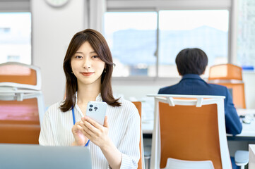 スマホを使うビジネスウーマン　若い女性　オフィス